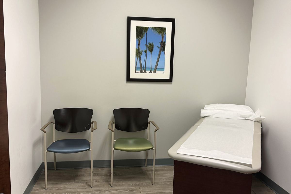 An exam room at our Dallas office, with the consulting table and two chairs.