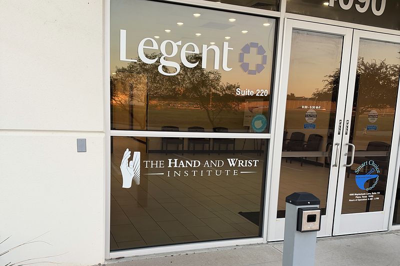 The glass entrance at 4090 Mapleshade Lane, with The Hand and Wrist Institute name on the door.
