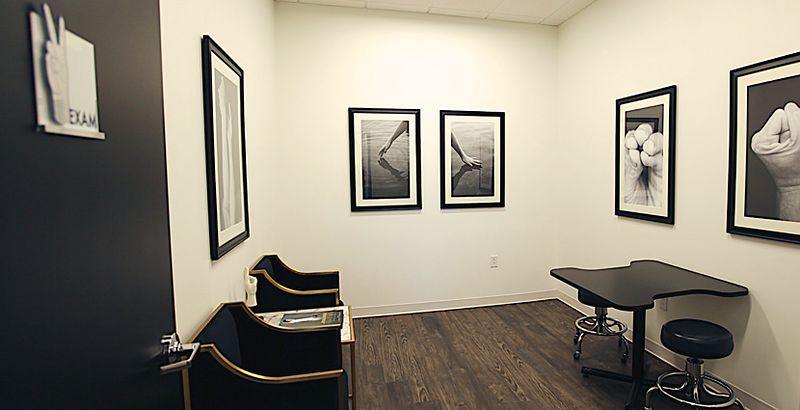 An exam room at our Southlake office, with the consulting table and framed photographs of hands.