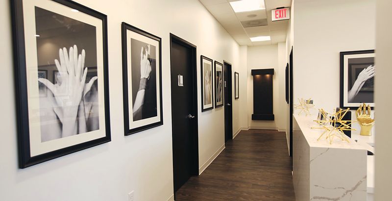 The corridor to the exam rooms at our Southlake office, hung with framed photographs of hands.