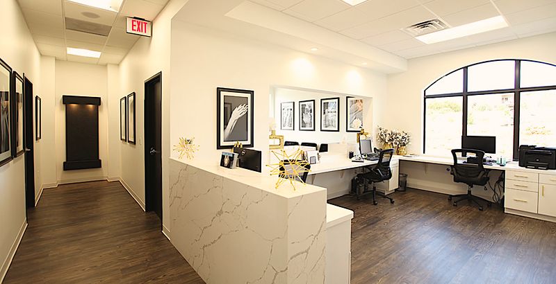The reception desk at our Southlake office, with the window wall and the staff work stations behind it.