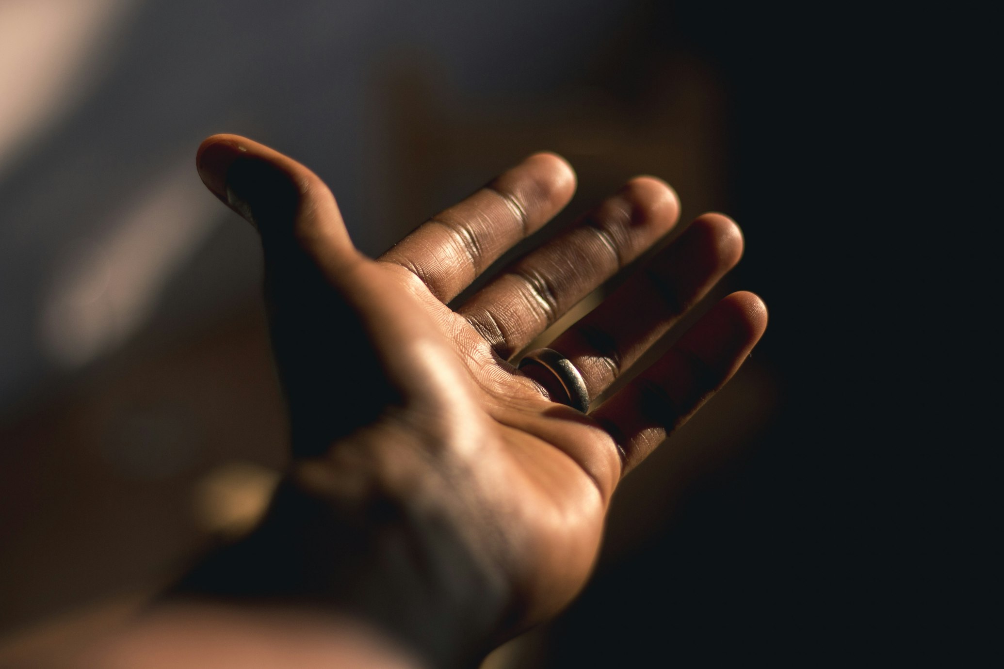 A hand held palm up in warm low light, the fingers curled.