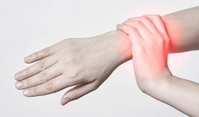 Person gripping their right hand due to pain in the wrist.