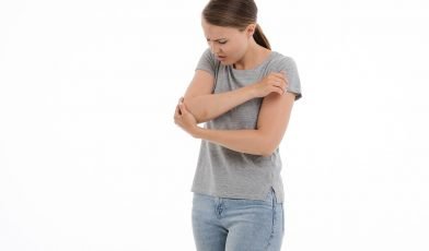 woman holding her elbow in pain