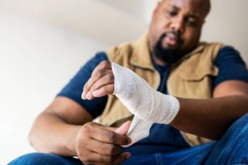 man wrapping up injured hand