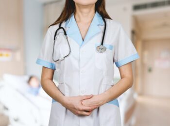 Doctor with stethoscope and arms folded in front of body.